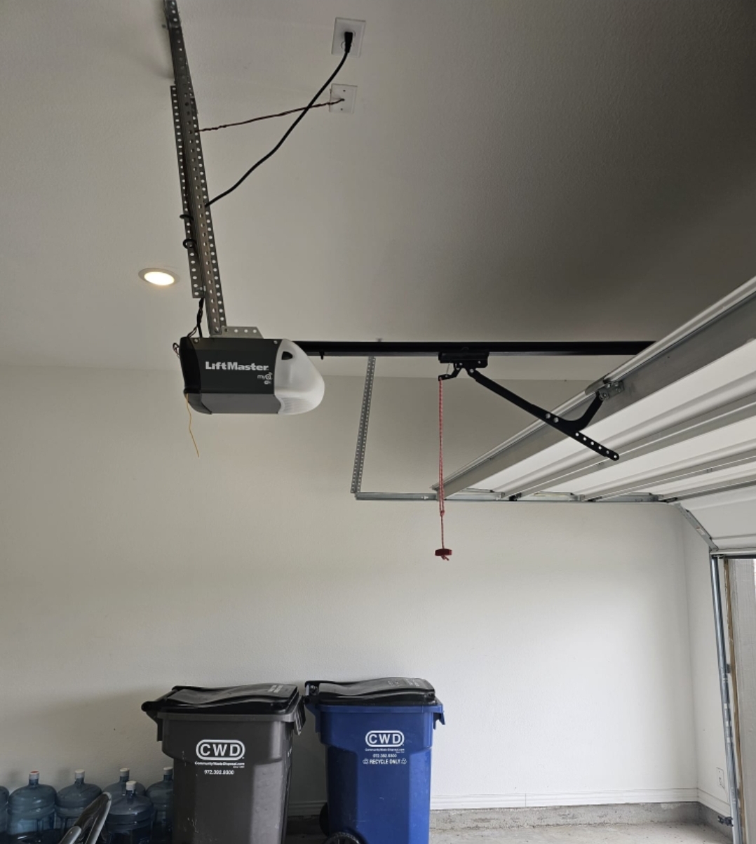 Newly installed LiftMaster garage door opener mounted to a garage ceiling with rail and arm
