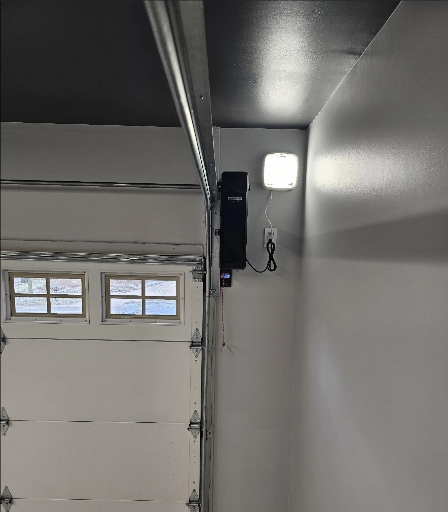 Wall-mounted jackshaft garage door opener installed beside a windowed door